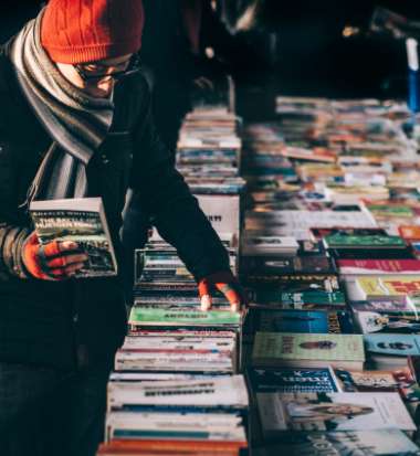 Eine Person stöbert zwischen Schallplatten auf eine Flohmarkt